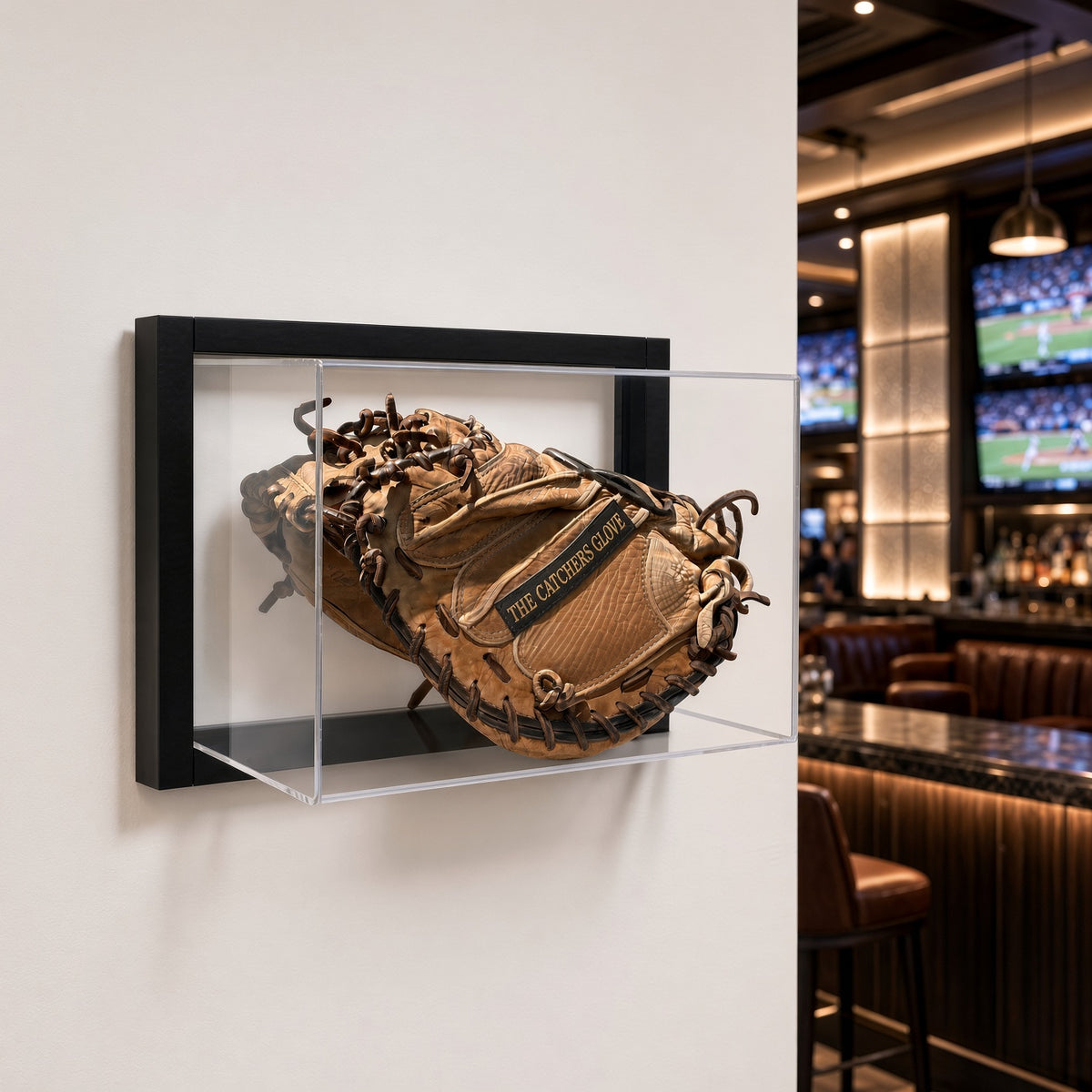 Framed baseball glove case mounted on a light wall next to a bar