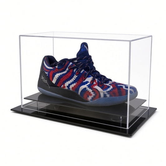 Table top acrylic shoe case with a black base holding a red, white and blue sneaker