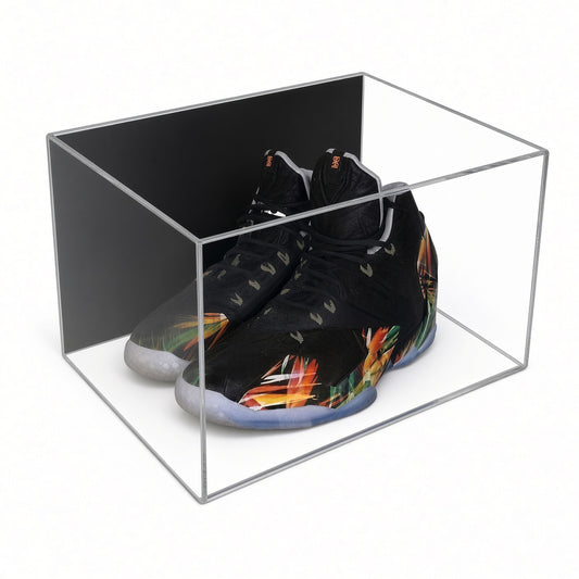 Acrylic wall mount case with a black back holding a pair of black sneakers